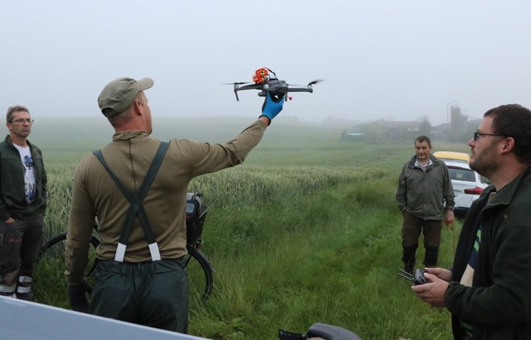Markus Wipf (l.) möchte seine Ökowiese mit gutem Gefühl mähen, Marco Signer (2.v.l.) und Michael Riedo (r.) schicken deshalb eine Drohne mit hochauflösender Wärmebildkamera über die Parzelle. Auch Jäger Richard Wipf mit Hund Falco ist dabei.