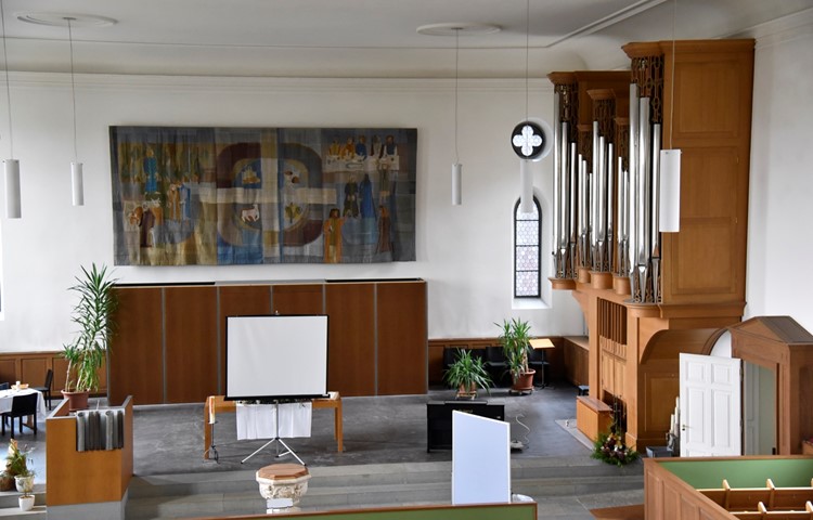 Der Chor der Kirche präsentiert sich heute mit Wandteppich und Orgel (rechts) hell und freundlich.