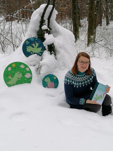 Im Schnee und Eis fühlt sich Drache Ronni vom Rhonegletscher zu Haus. Die Autorin, Cornelia Zahner, setzte sich für das Bild den kühlen Temperaturen in einem Waldstück in Niedermarthalen aus.