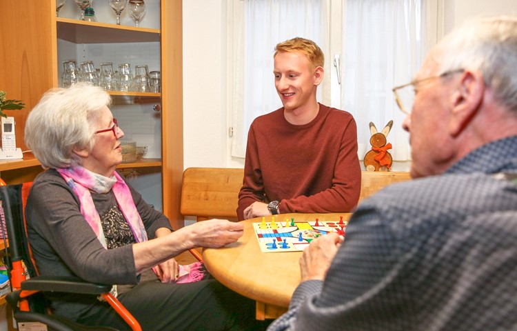 Aktivierung ist ein wichtiger Bestandteil der professionellen Betreuung. Hier macht der Lernende Lars Gächter ein Gesellschaftsspiel mit zwei Tagesgästen.