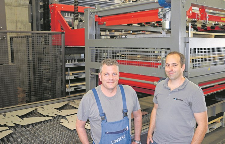 Andreas Sauter und Lukas Riedo (rechts) vor der Faserlaseranlage mit automatischem Blechlager.