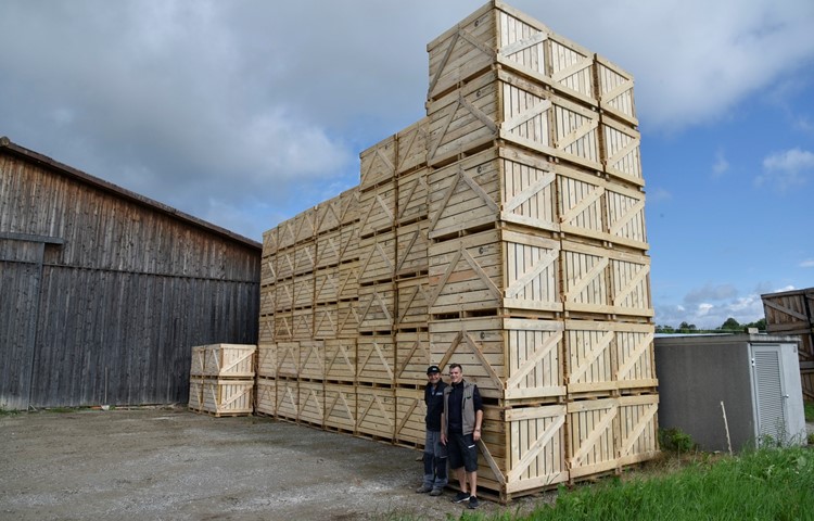 Landwirt Jürg Gisler (links) und Martin Germann, Geschäftsführungsmitglied der Landi Weinland, freuen sich über die Paloxen aus Schweizer Käferholz. Neben der Scheune auf dem Hof in Flaach ragt bereits ein Turm in die Höhe.