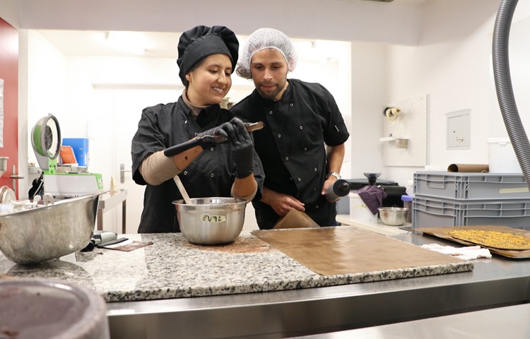 Mayra Núñez und Felix Bauer überprüfen in ihrem Atelier, ob die geschmolzene Schokolade richtig temperiert ist.