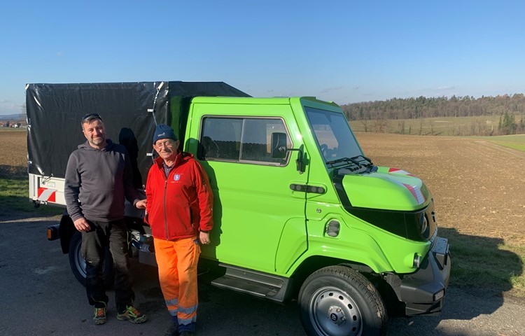 Die Gemeindearbeiter Felix Bernhard und Walter Eggli freuen sich über das neue E-Kommunalfahrzeug in Uhwiesen.