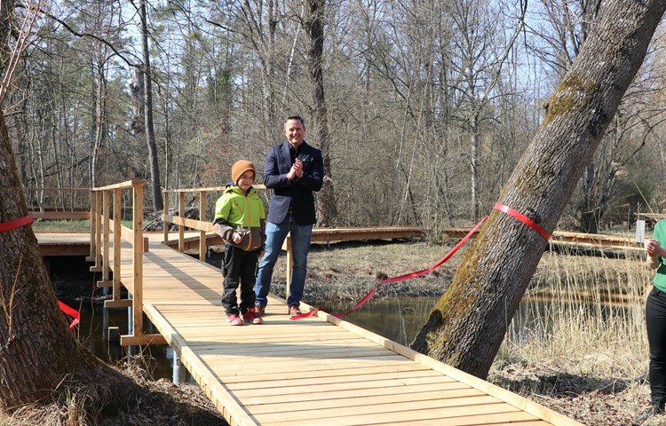 Feierlich eröffnet: Projektleiter Michael Meier schneidet mit Unterstützung eines jungen Besuchers das rote Band zum renovierten Steg durch.