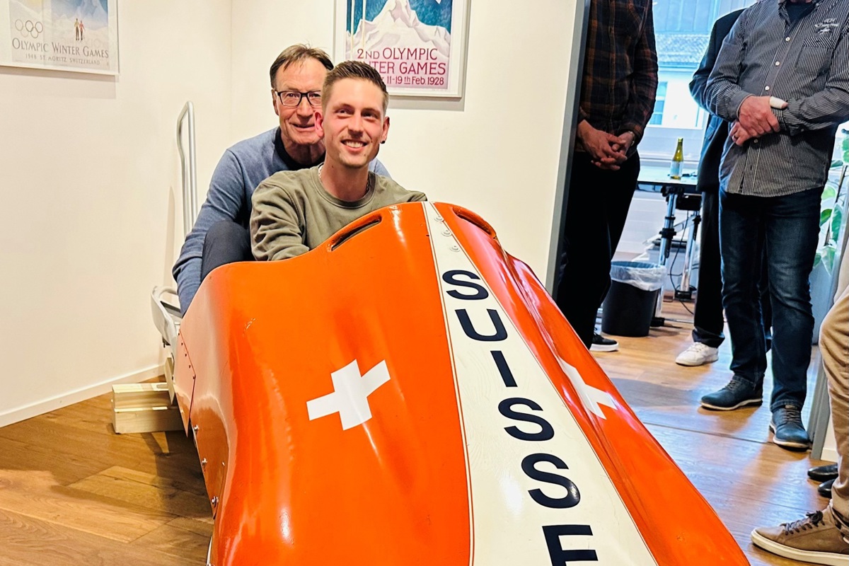 Lars Werner (vorne) war federführend bei der Restaurierung des historischen Bobs, der nun in der Anwaltskanzlei von Daniel Mägerle steht. Zur «Bobtaufe» eingeladen war auch der ehemalige Anschieber Karl Häseli (hinten).