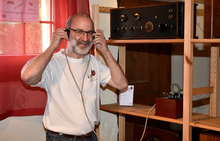Markus Müller zeigt eines der ersten Detektorenradios, mit dem Funkwellen nur über Kopfhörer hörbar wurden.