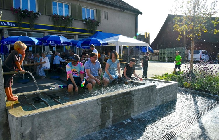 Eine Abkühlung im Dorfbrunnen mit Wasserspritzern gehörte auch für manchen Erwachsenen zum Strassenfest.