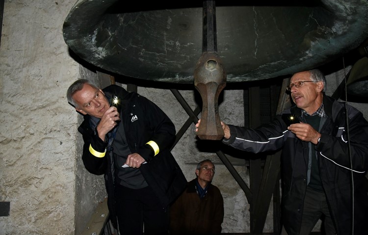 Kirchenpfleger Urs Weilenmann (r.) erklärt im Glockenturm der Kirche Flaach, wann welche der vier Glocken wie angeschlagen wird und warum die Stundenschläge leiser sind als das eigentliche Geläut.