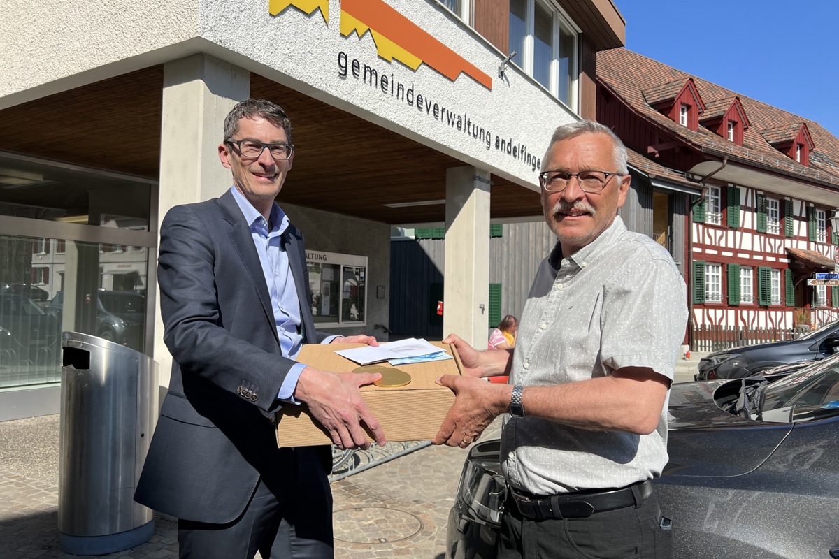 Thomas Müller von der ZKB Andelfingen überreicht Gemeindepräsident Hansruedi Jucker (rechts) das Geld in Papierform Thomas Müller von der ZKB Andelfingen überreicht Gemeindepräsident Hansruedi Jucker (rechts) das Geld in Papierform