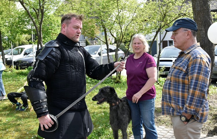 Der Bergemer Gemeinderat André Gschwend (links) erklärt Zweckverbandspräsident Daniel Sieber und einer Zuschauerin den Kampf mit einem Säbel.