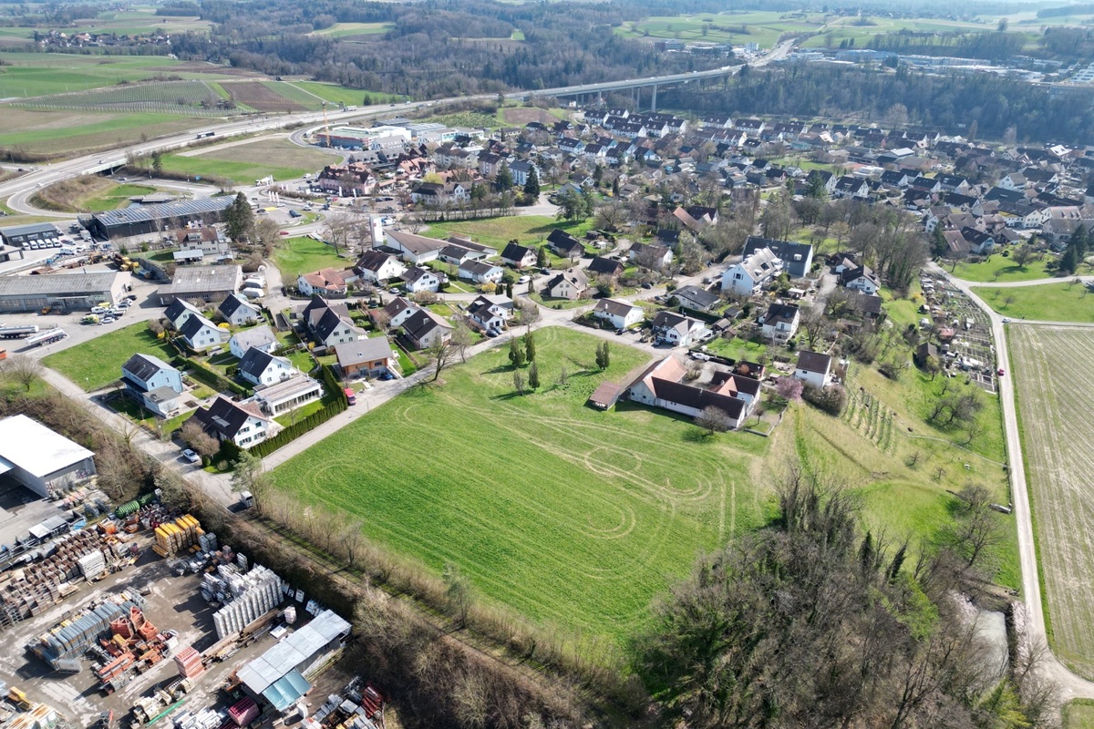Wiese mit Platz für 48 Wohnungen und 97 Tiefgaragenplätzen – Mühe hat die Nachbarschaft mit dem zu erwartenden Verkehr. Die strassenmässige Erschliessung hat gemäss dem 1992 vom Regierungsrat genehmigten Quartierplan durch die Gass (die quer durchs Bild verläuft) zu erfolgen. Wiese mit Platz für 48 Wohnungen und 97 Tiefgaragenplätzen – Mühe hat die Nachbarschaft mit dem zu erwartenden Verkehr. Die strassenmässige Erschliessung hat gemäss dem 1992 vom Regierungsrat genehmigten Quartierplan durch die Gass (die quer durchs Bild verläuft) zu erfolgen.