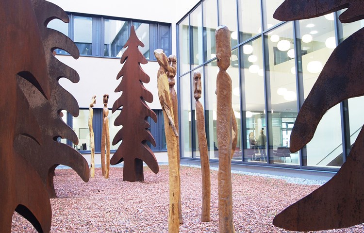 Zu den Tannen eines heimischen Metallbearbeiters gesellen sich in einem der Innenhöfe des neuen Spitals Limmattal Holzskulpturen von Ruedi Karrer.