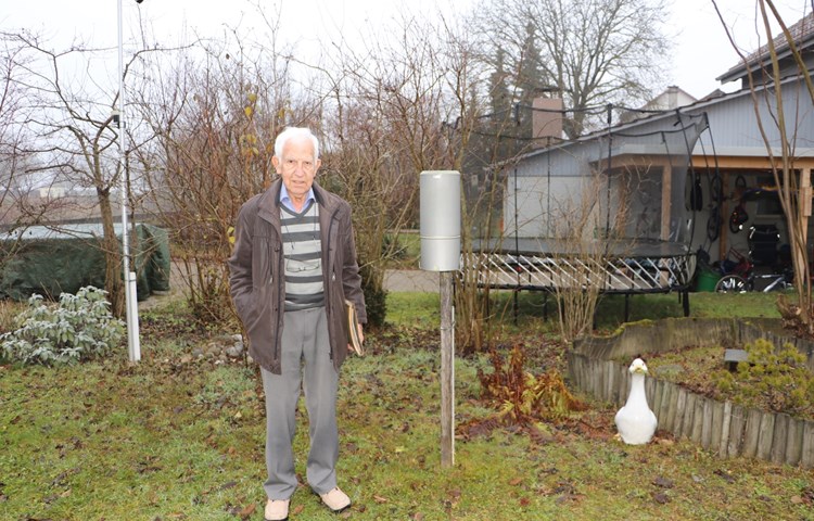 Robert Tanner in seinem Garten beim Herzstück seiner Wetterstation: dem metallenen Regenmesser.