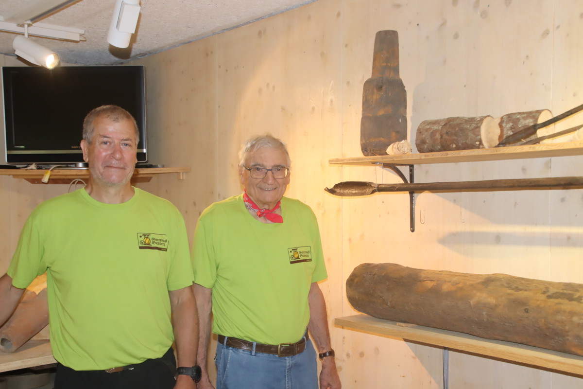 Peter Baumann (links) und Otto Weilenmann mit ausgestellten Holzleitungen, die bis Mitte des 19. Jahrhunderts zum Einsatz kamen. Am nationalen Mühlentag am kommenden Wochenende werden solche in der Gattersagi hergestellt.