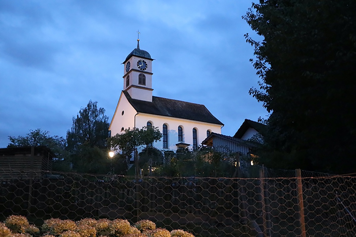 Steht im Dunkeln: Die reformierte Kirche Henggart von der Dorfstrasse aus gesehen. Steht im Dunkeln: Die reformierte Kirche Henggart von der Dorfstrasse aus gesehen.