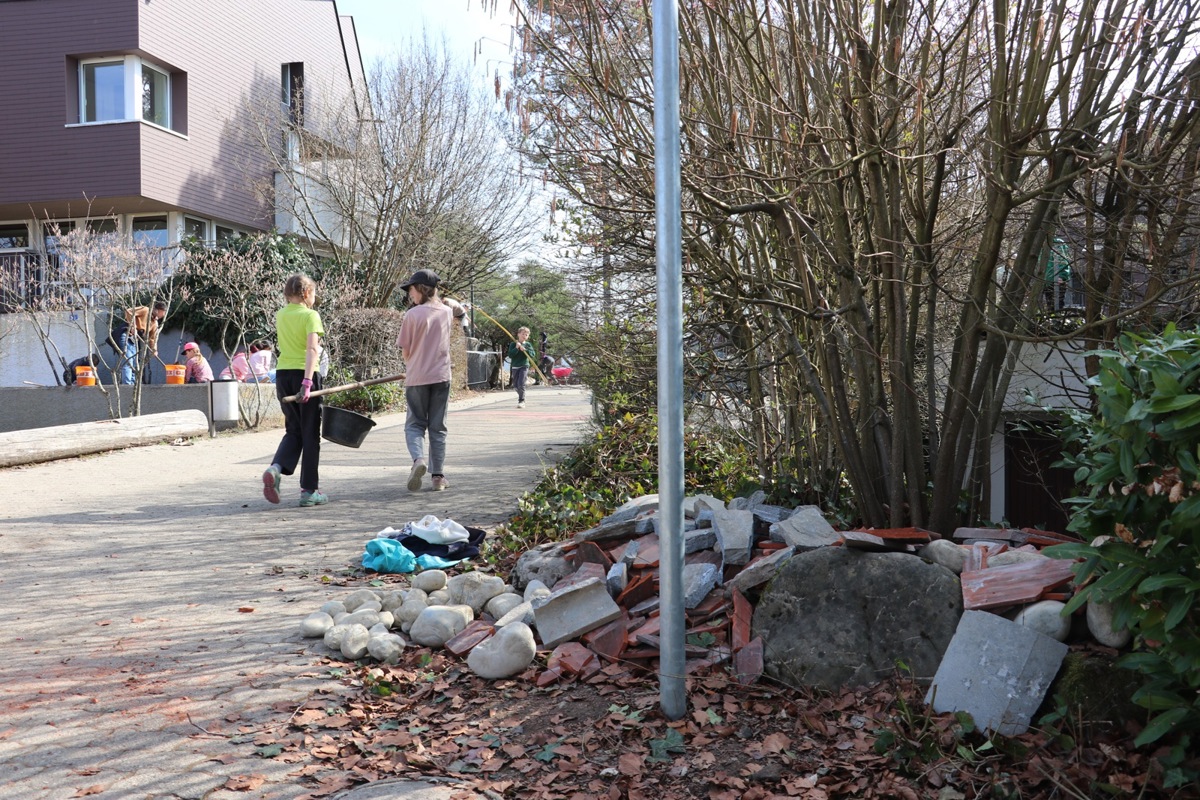 Um den Steinhaufen aufzuschütten, ist Teamarbeit gefragt. Im Hintergrund wird an einer Ruderalfläche gearbeitet. 