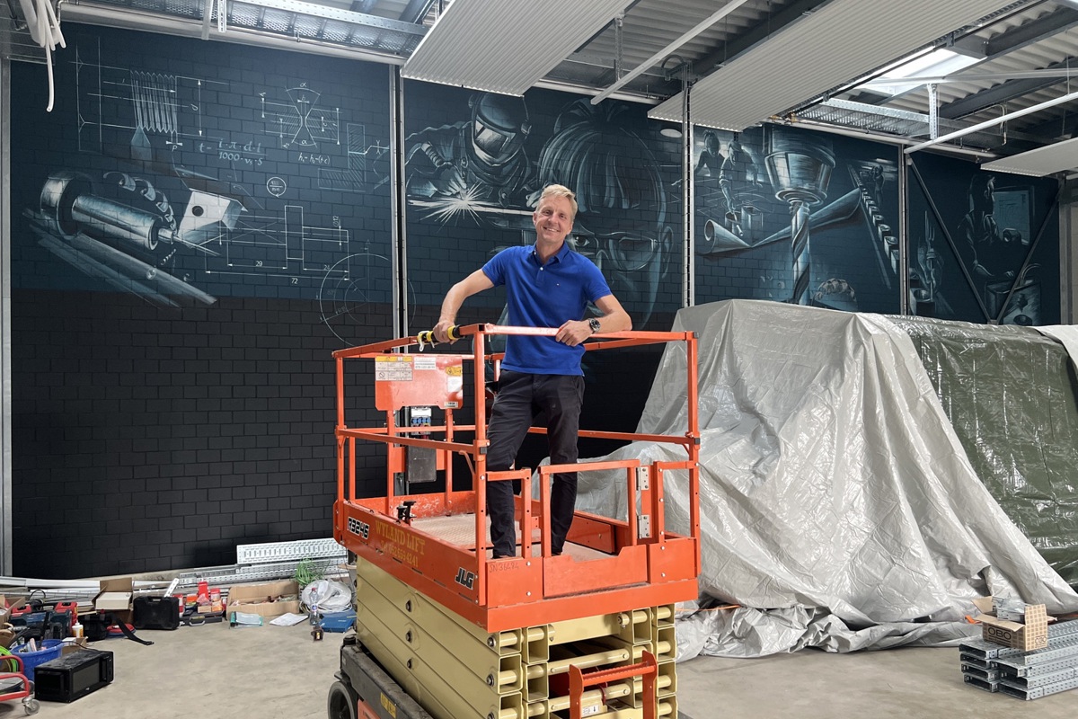 Zwei neue Maschinen sind schon da, der Rest kommt noch und muss eingerichtet werden: Michael Höpli in der Maschinenhalle, die Elemente an der Wand sind gemalt.