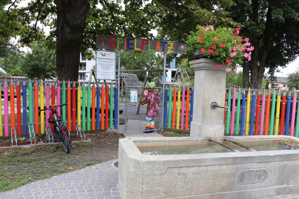 Der Spielplatz Webergasse in Flaach ist physisch klar von seiner Umgebung abgetrennt. Schilder am Eingang kommunizieren die Regeln und die Öffnungszeiten.