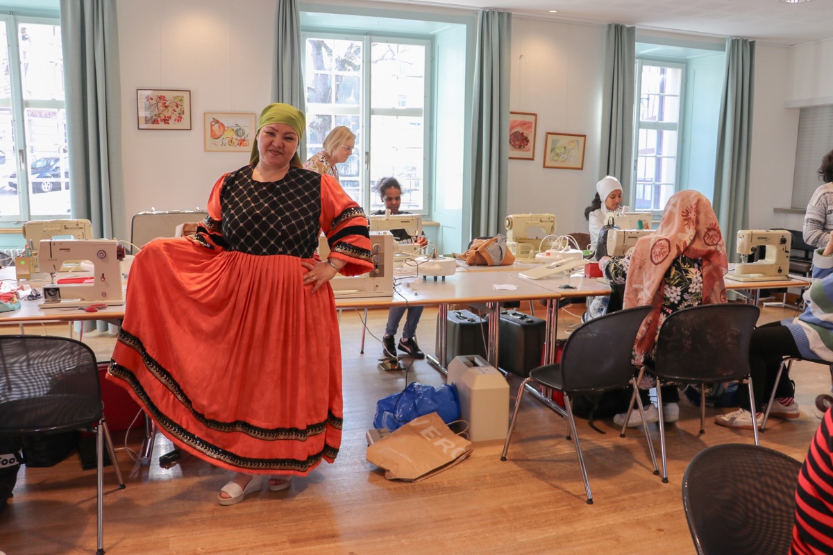 Maryam Jafari zeigt ihr selbst genähtes Kleid. Im Saal des Kirchgemeindehauses wurde ein Nähatelier für geflüchtete Frauen eingerichtet.  Maryam Jafari zeigt ihr selbst genähtes Kleid. Im Saal des Kirchgemeindehauses wurde ein Nähatelier für geflüchtete Frauen eingerichtet.