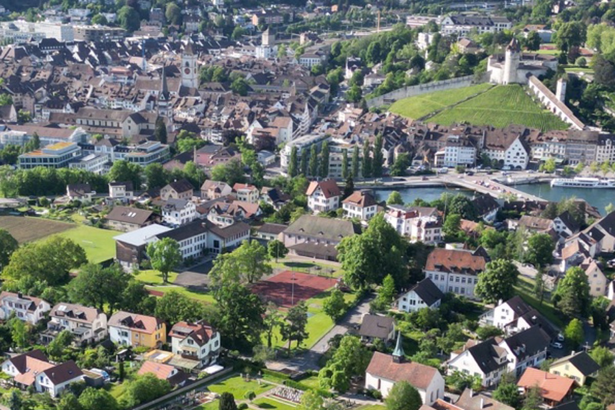 Das Areal Spilbrett: Die neue Halle ist anstelle des sanierungsbedürftigen Roten Platzes vorgesehen, die Parzelle 2000, im Bild der dunkle Acker links, soll verkauft werden. Im Zentrum Spilbrett, das Haus rechts mit Dachgauben, werden noch dieses Jahr zwei Schulzimmer und Gruppenräume für die Sek untergebracht.