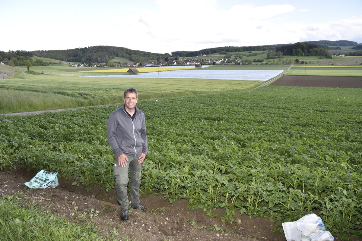Martin Roth vor seinen Feldern – das vordere Kartoffelfeld ist bereits abgedeckt