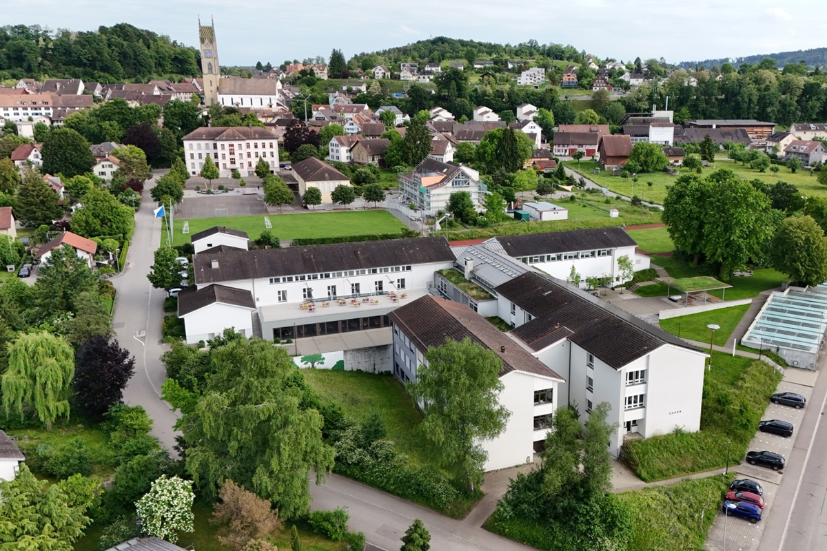 Blick auf die Andelfinger Schulanlagen. Vorne die Sek – zwischen den beiden längs stehenden Gebäuden ist der Lifteinbau bereits erfolgt. In der Bildmitte das Haus Hofwiesen der Primarschule, das aufs neue Schuljahr im August fertig umgebaut und erweitert ist.