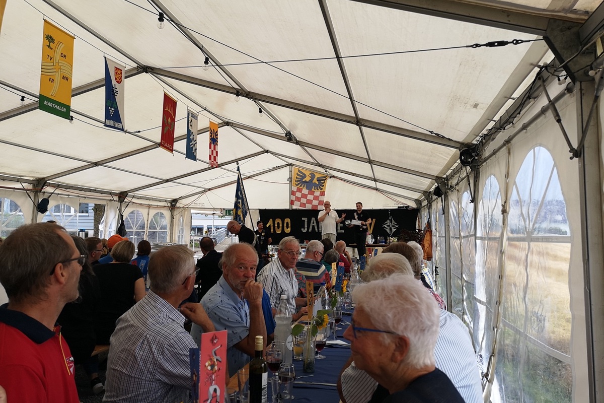 Gemeindepräsident Bruno Kräuchi (weisses Shirt) überreicht Vereinspräsident Florian Kistler bei der 100-Jahr-JubiläumFeier des TV Hettlingen einen Gutschein über 1000 Franken als Geschenk. Gemeindepräsident Bruno Kräuchi (weisses Shirt) überreicht Vereinspräsident Florian Kistler bei der 100-Jahr-JubiläumFeier des TV Hettlingen einen Gutschein über 1000 Franken als Geschenk.