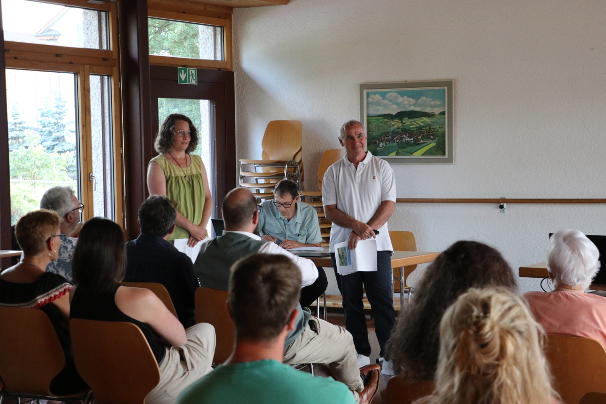 Ursula Ganz und Walter Schürch (beide stehend) erklären den Anwesenden die Notwendigkeit der Sanierung der Waldstrasse Hintere Eggstrasse.